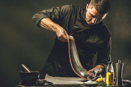 Ein Koch beim Zubereiten eines Fisches