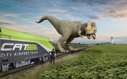 Ein Dinosaurier steht auf einem Bahngleis, zerstört die Weichen und hält den Zug auf