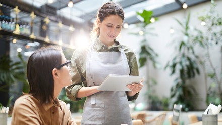 Eine Kellnerin nimmt eine Bestellung auf.