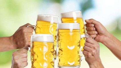 Vier Personen stoßen mit ihrem Bier an