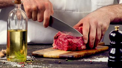 Ein Koch, der Fleisch schneidet