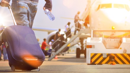 Ein Fluggast geht auf ein Flugzeug zu