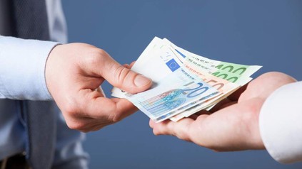 Mann überreicht Geldscheine