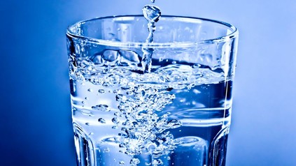 Ein Glas wird mit Wasser gefüllt