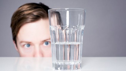 Ein Mann starrt ein Wasserglas an