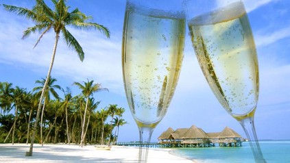 Ein Palmenstrand und zwei volle Sektgläser