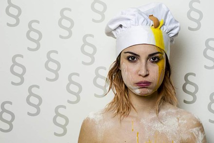 Eine frustrierte und schmutzige Köchin, von Paragrafenzeichen umgeben.