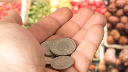 Ein Kunde mit Centstücken in einem Supermarkt