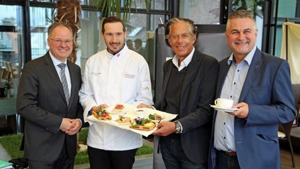 Christian Mayerhofer, Philipp Stohner, Jürgen Bodenseer und Goran Huber halten gemeinsam einen Teller mit Speisen