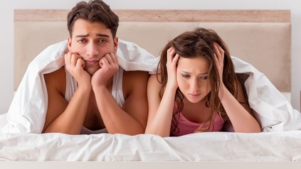 Mann und Frau genervt in Bett