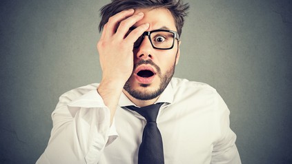 Schockierter junger Mann sieht in die Kamera