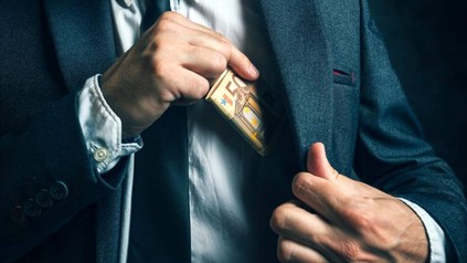 Ein Mann steckt sich einen 50€ Schein in die Hemdtasche