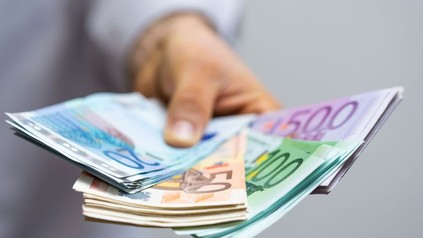 Eine Person, die einige Geldscheine in der Hand hält