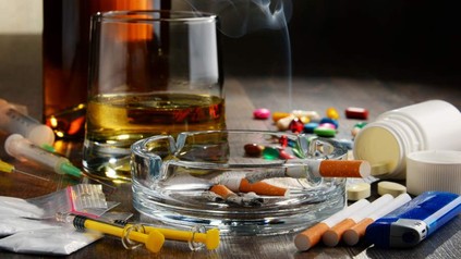 Brennende Zigarette im Aschenbecher, Whiskeyglas