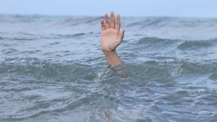 Person ertrinkt, Hand ragt aus Wasser