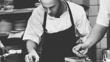 Koch bereitet Essen in Küche zu