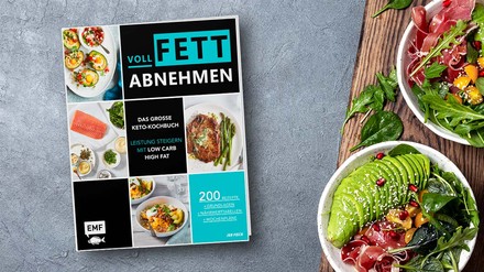 Das Kochbuch „Voll Fett abnehmen“ liegt auf einem Tisch neben zwei Schüsseln mit Salat, Avocado und Schinken