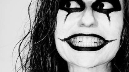 Frau mit Clownschminke grinst