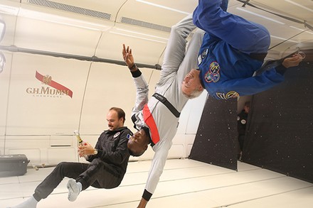 Drei Männer und eine Flasche Sekt in der Schwerelosigkeit