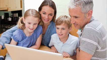 Familie sieht gemeinsam auf Laptop