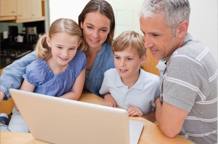 Familie sieht gemeinsam auf Laptop