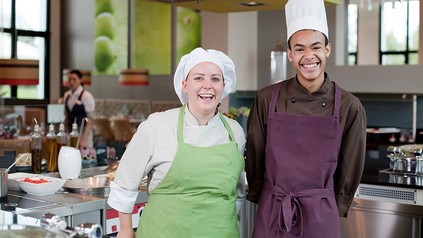 Zwei lachende junge Köche in einer Küche