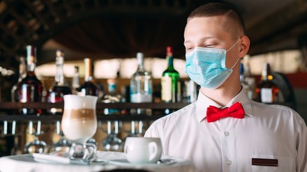 ein Kellner mit Corona-Maske