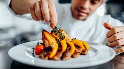 Ein Koch bereitet eine Speise zu