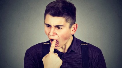 Mann steckt sich Finger in den Hals