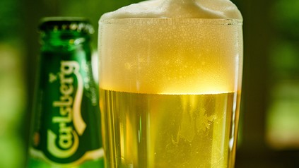 Eine Bierdose und ein Glas voller Carlsberg Bier