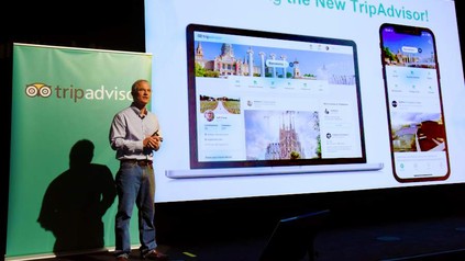 Ein Referent vor einer Leinwand, der den Trip Advisor vorstellt