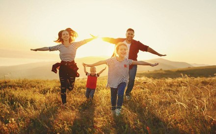 Familie läuft über herbstliche Wiese