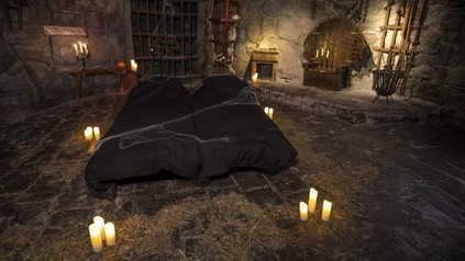 Ein düsteres Hotelzimmer im Berlin Dungeon, das an eine Gruft erinnert