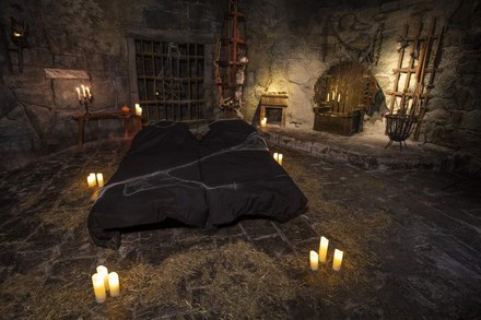 Ein düsteres Hotelzimmer im Berlin Dungeon, das an eine Gruft erinnert