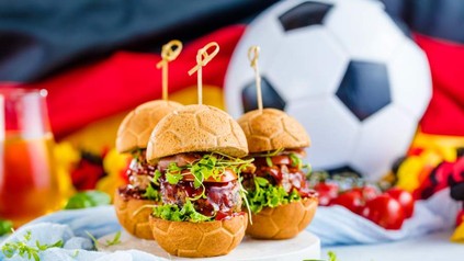 Ein Fußball und drei Hamburger vor einer deutschen Flagge