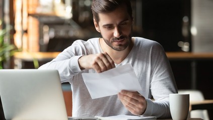 Mann in Café mit Brief in der Hand