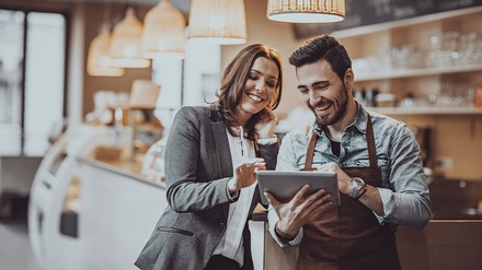 Gastronomen-Paar checkt mit einem lächeln die aktuellen Zahlen