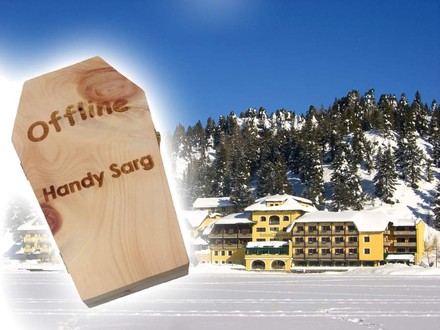 Das Hotel Jägerwirt von außen und ein Holzsarg auf dem Offline Handy Sarg steht
