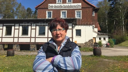 Frau vor erster deutschen Autobahnraststätte