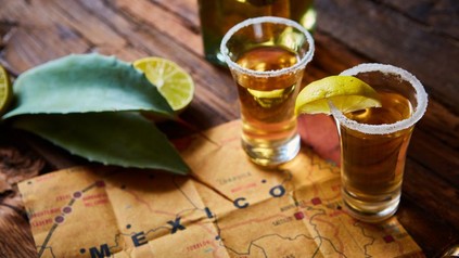 Zwei Tequila Shots auf Tisch mit Zitronenscheiben