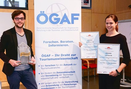 MCI-Absolventen Lena Hüttl (rechts) und Moritz Busch nehmen ihre Auszeichnungen sowie die Trophäe für das MCI als beste Tourismus-Ausbildungsstätte Österreichs in Empfang