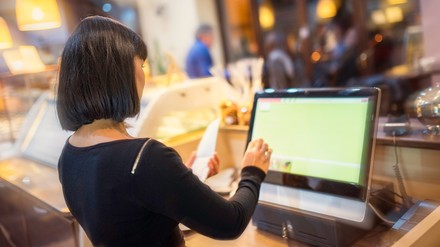 Kassiererin an einer digitalen Kasse