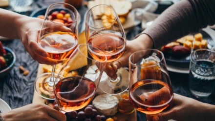 Freunde stoßen mit Wein an