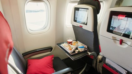 Flugzeugsitz mit Tisch voller Essen
