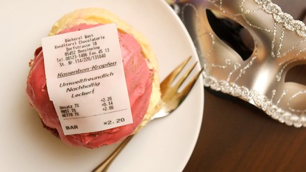 Ein Kassenbon au8s Zuckerguss auf einem Krapfen.