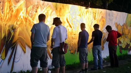 Mehrere Männer pinkeln an eine Wand