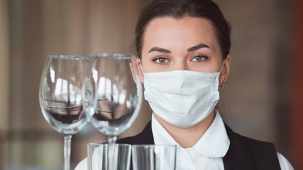 Eine Kellnerin mit Gesichtsmaske