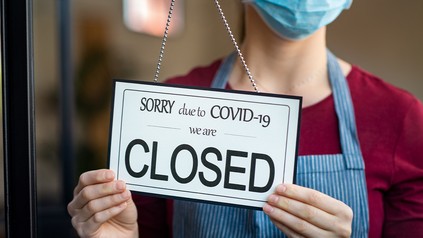 Gastronom hängt ein Geschlossen-Schild an die Restauranttür