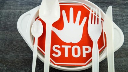 Ein Plastikgeschirr mit einem Stoppschild daneben