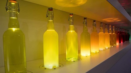 Eine Reige Getränkeflaschen, die im Dunkeln leuchten